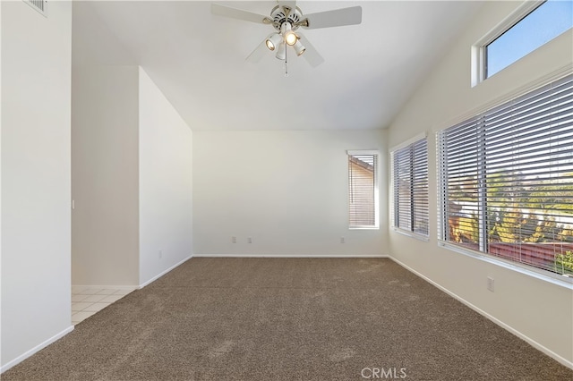 carpeted empty room featuring lofted ceiling, plenty of natural light, baseboards, and a ceiling fan