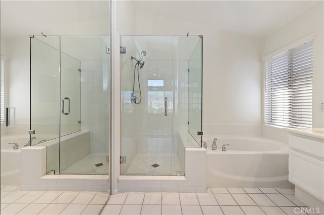 bathroom with a stall shower, tile patterned flooring, and a bath