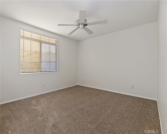 spare room with carpet, baseboards, and a ceiling fan