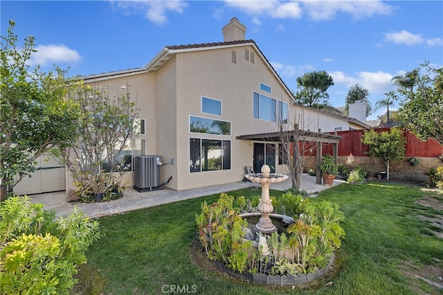 back of house featuring central AC, a yard, stucco siding, a pergola, and a patio area