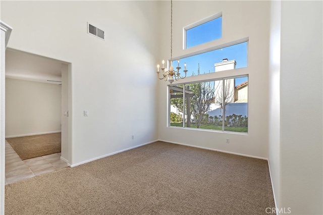 unfurnished room featuring baseboards, visible vents, a towering ceiling, carpet floors, and a notable chandelier