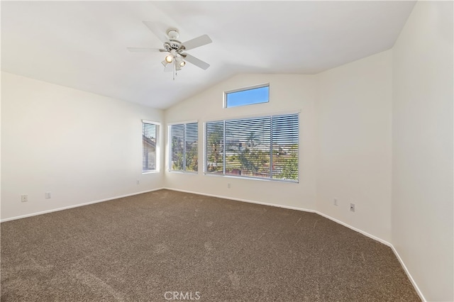 empty room with lofted ceiling, dark colored carpet, and baseboards