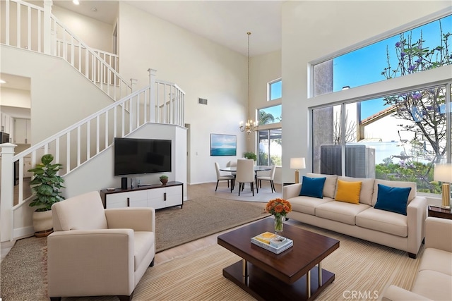 living area with visible vents, a notable chandelier, and stairs