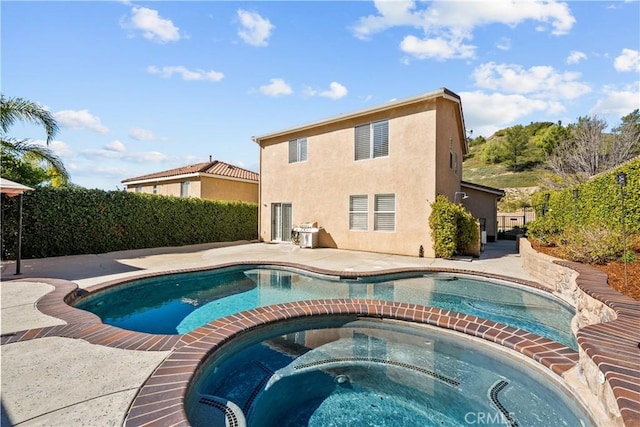 view of pool with a patio area and a pool with connected hot tub