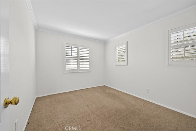 carpeted spare room with baseboards and crown molding