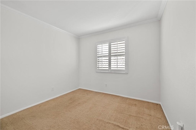 carpeted spare room featuring crown molding and baseboards