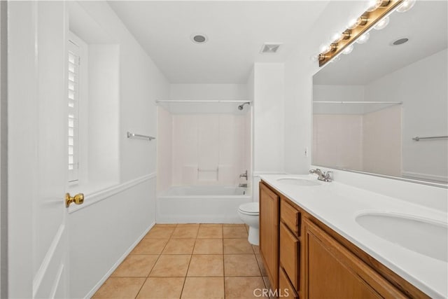 full bathroom with double vanity, a sink, toilet, and tile patterned floors