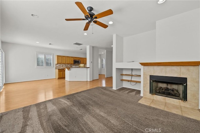 unfurnished living room featuring recessed lighting, visible vents, a fireplace, and light carpet