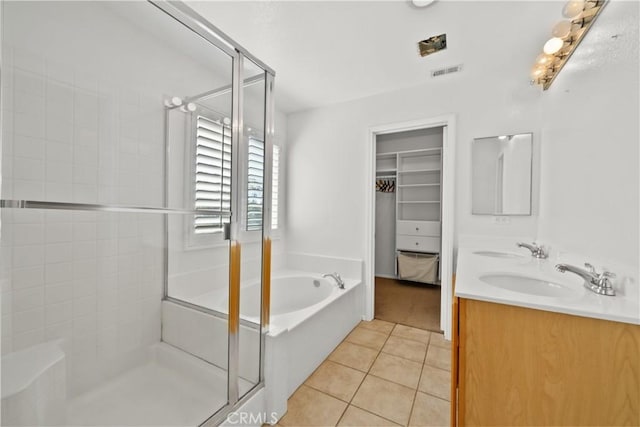 full bath with a stall shower, tile patterned flooring, visible vents, and a sink