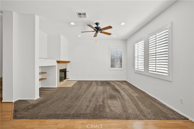 unfurnished living room featuring recessed lighting, visible vents, ceiling fan, wood finished floors, and a tile fireplace