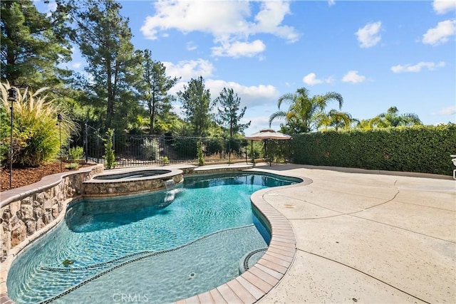 view of pool with a pool with connected hot tub, fence, and a patio