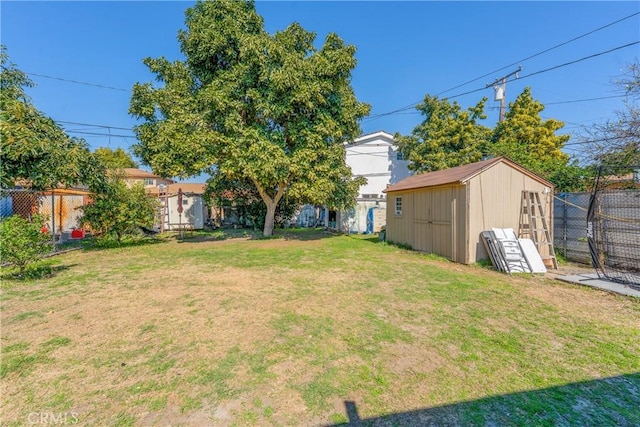 view of yard with a fenced backyard, an outdoor structure, and a storage shed