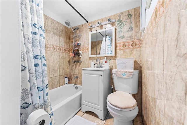 bathroom featuring tile patterned flooring, toilet, vanity, tile walls, and shower / bath combo with shower curtain