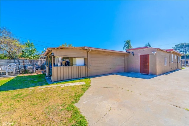 view of front of property featuring driveway, a front lawn, and stucco siding