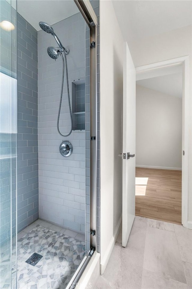 full bathroom featuring a shower stall, baseboards, and tile patterned flooring