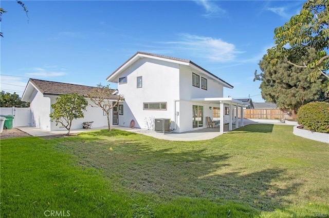 back of property with a fenced backyard, a yard, and central AC