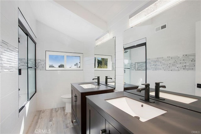 bathroom with two vanities, a sink, visible vents, and tile walls