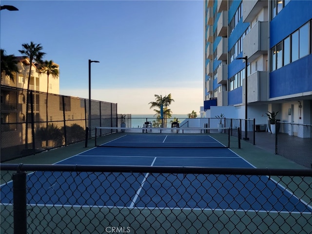 view of tennis court featuring fence