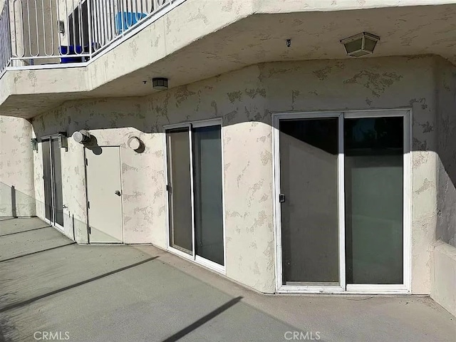 view of side of property with a patio area and stucco siding