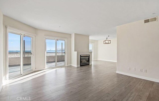 25 15th Pl Unit 101, Long Beach, CA 90802 - unfurnished living room with dark wood-style floors, baseboards, a glass covered fireplace, and a water view