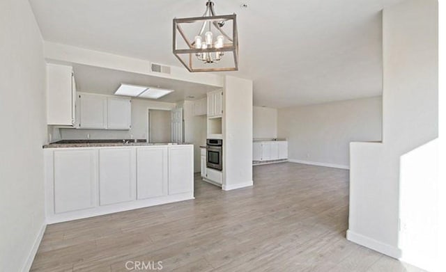 25 15th Pl Unit 101, Long Beach, CA 90802 - kitchen featuring stainless steel oven, open floor plan, baseboards, and a peninsula