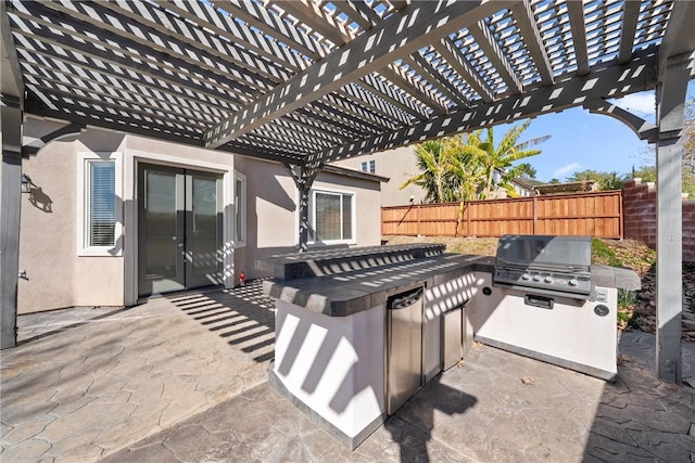 view of patio / terrace with french doors, grilling area, an outdoor kitchen, fence, and a pergola