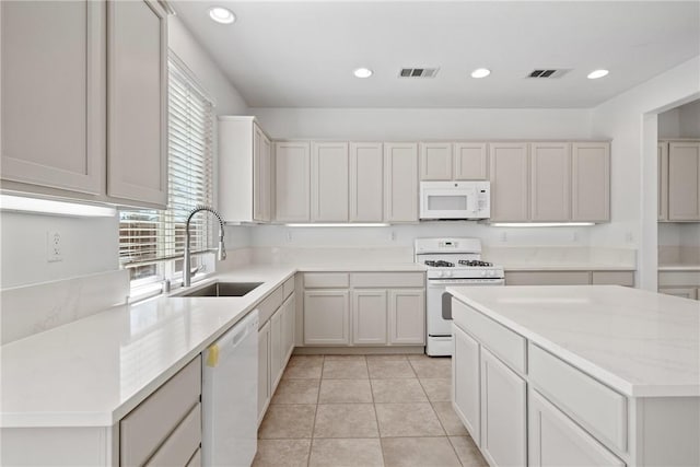 kitchen featuring recessed lighting, white appliances, visible vents, and a sink