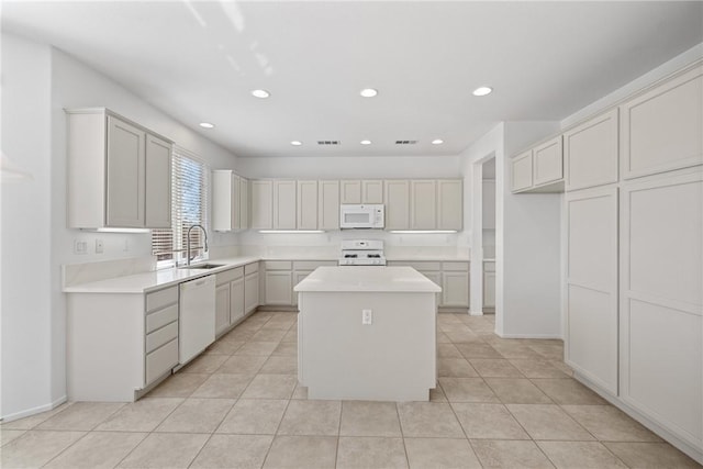 kitchen featuring light tile patterned floors, light countertops, white appliances, and a center island