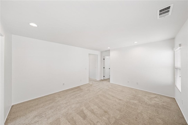 spare room with recessed lighting, visible vents, and light colored carpet