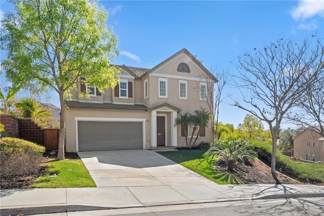 traditional home with a garage, concrete driveway, fence, and stucco siding