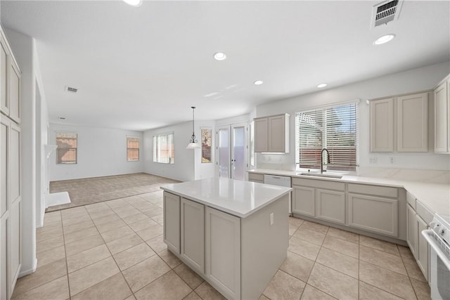 kitchen with a center island, light tile patterned floors, visible vents, wall oven, and a sink