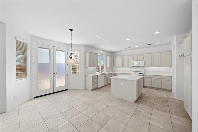 kitchen with white appliances, a kitchen island, light countertops, french doors, and recessed lighting