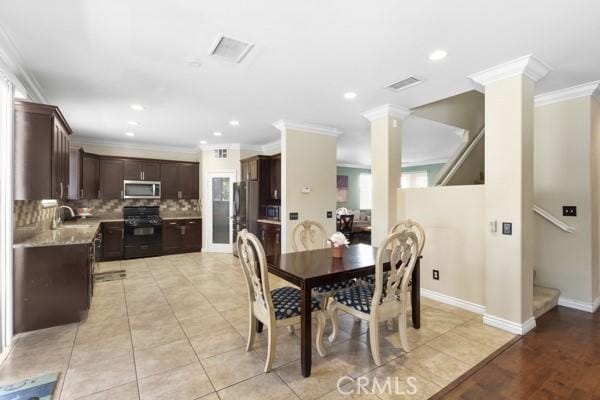 dining space with crown molding, decorative columns, light tile patterned floors, visible vents, and stairway