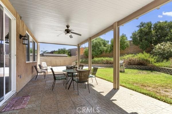 view of patio featuring outdoor dining space, a fenced backyard, and ceiling fan