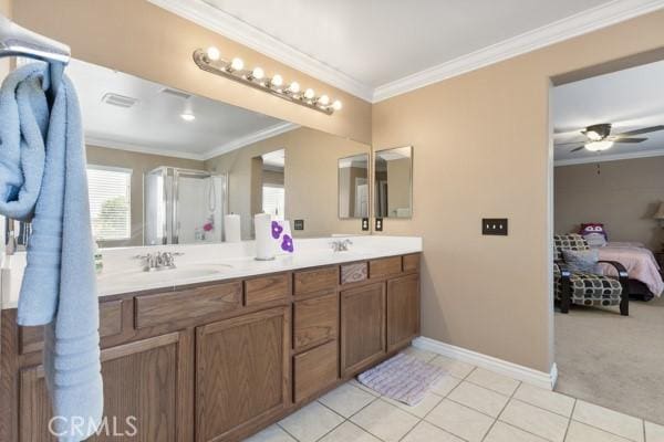 ensuite bathroom featuring baseboards, double vanity, tile patterned flooring, and crown molding