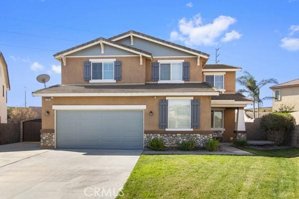 craftsman house featuring an attached garage, fence, driveway, stucco siding, and a front yard