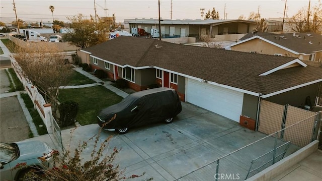 view of front of home featuring a garage, concrete driveway, a shingled roof, and a residential view