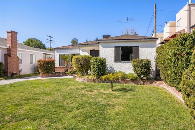 view of front of property featuring a front lawn and stucco siding