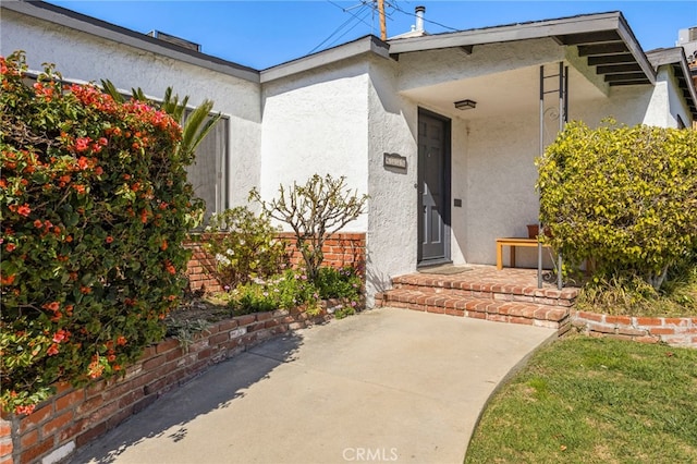 view of exterior entry featuring stucco siding