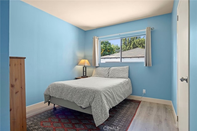 bedroom featuring wood finished floors and baseboards