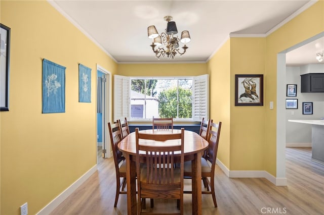 dining space featuring an inviting chandelier, light wood-style floors, and ornamental molding