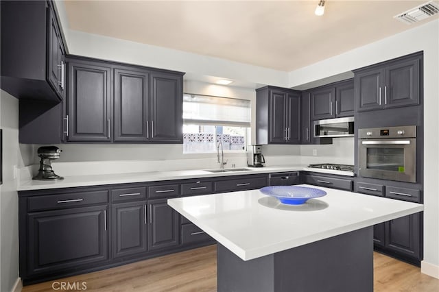 kitchen with appliances with stainless steel finishes, visible vents, light countertops, and a sink