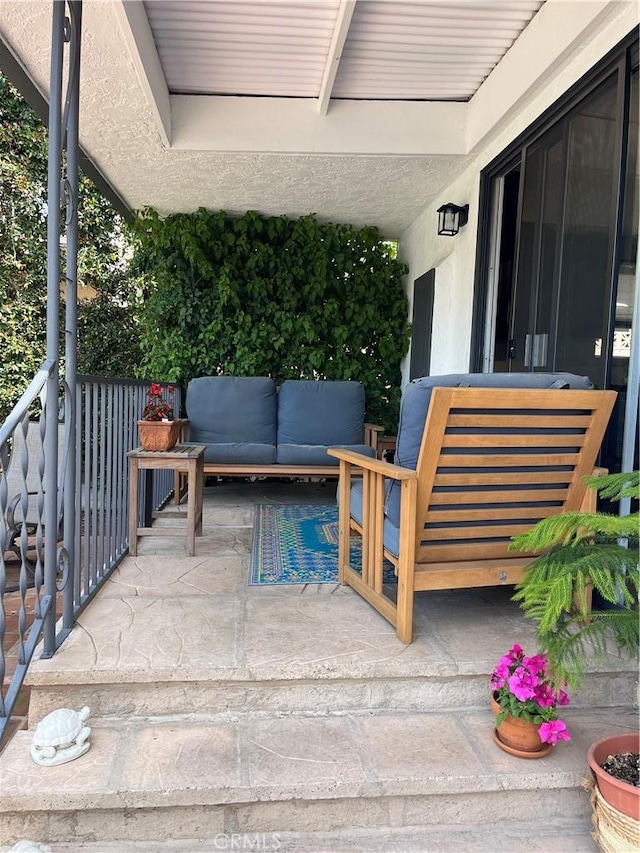 view of patio featuring outdoor lounge area and a balcony