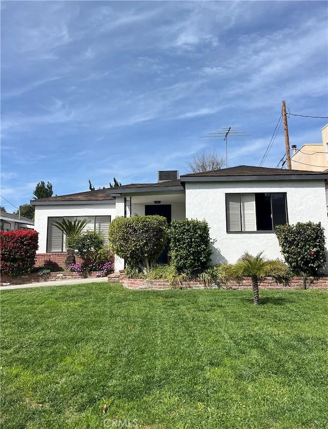 single story home with a front lawn and stucco siding