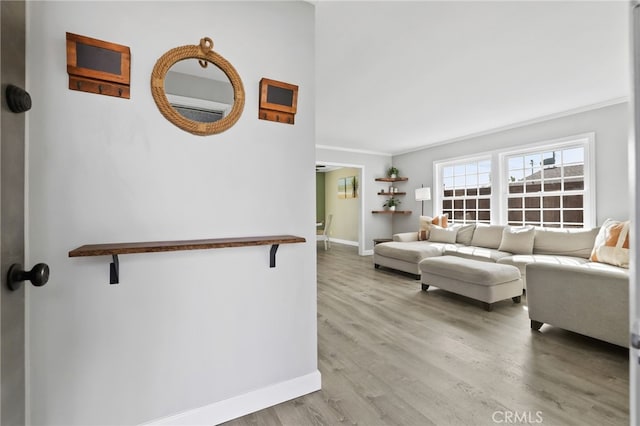 living room featuring ornamental molding, baseboards, and wood finished floors