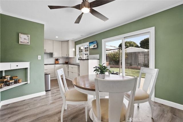 dining room with baseboards, ceiling fan, and light wood-style floors