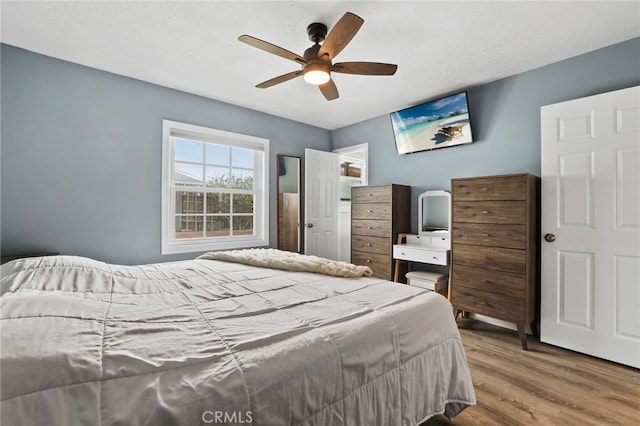 bedroom featuring a textured ceiling, wood finished floors, and a ceiling fan