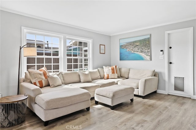 living room with light wood-style floors, baseboards, and crown molding