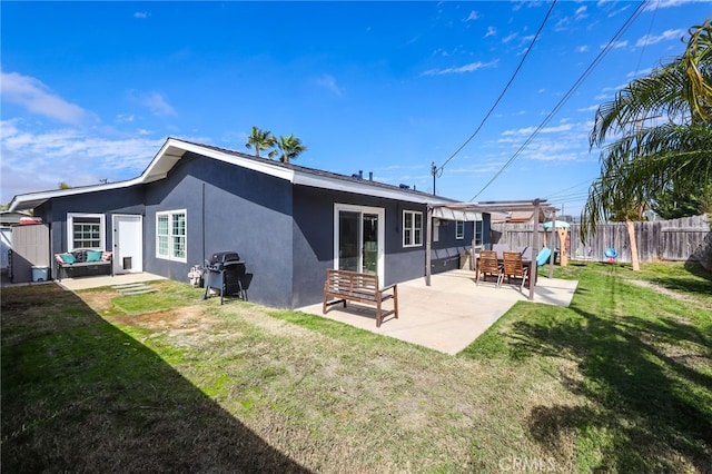 back of property with a patio area, a yard, fence, and stucco siding