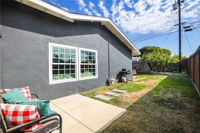 view of property exterior with a yard, a patio area, a fenced backyard, and stucco siding